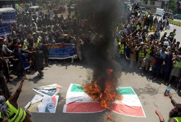 Пакистанские активисты собрались возле горящего индийского флага во время акции протеста в Музаффарабаде, административном центре пакистанской территории Азад Джамму и Кашмир, с целью показать свою солидарность с индийскими кашмирскими мусульманами