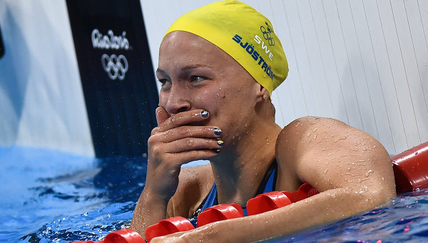Сара Шестрем (Швеция) радуется 1-му месту в финальном заплыве на 100 м баттерфляем