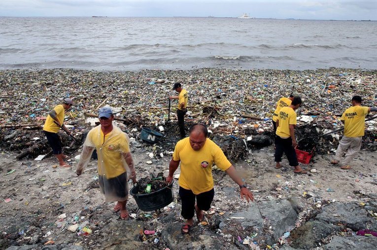 Правительственные работники собирают мусор в Маниле