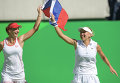 Екатерина Макарова и Елена Веснина (Россия) радуются победе в финальном матче против Тимеи Бачински и Мартины Хингис (Швейцария)