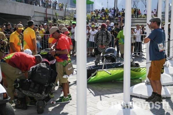 Военнослужащие и волонтеры стоят в оцеплении у места падения подвесной телекамеры упавшей на людей в Олимпийском парке в Рио-де-Жанейро