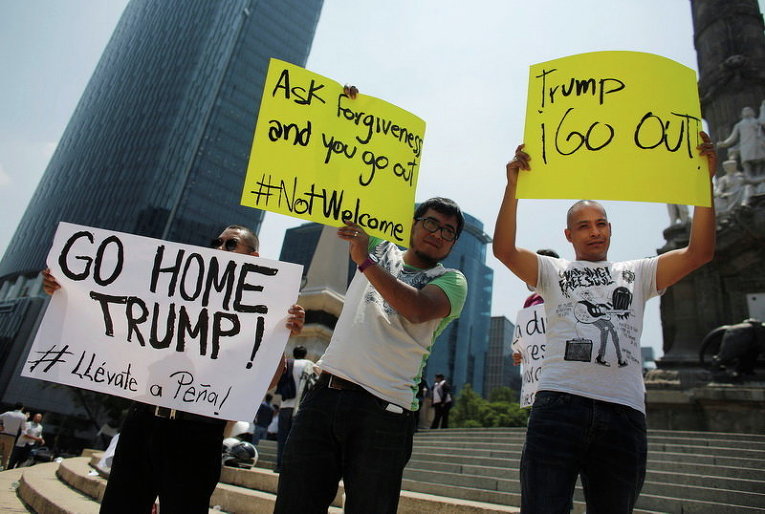 Демонстранты держат плакаты во время акции протеста против визита кандидата в президенты США Дональда Трампа в Мехико, Мексика