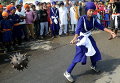 Девушка демонстрирует навыки боевых искусств во время шествия в Батала, Индия