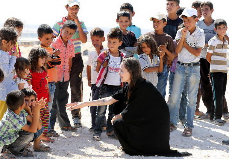 Американская актриса и спецпредставитель УВКБ ООН Анджелина Джоли беседует с детьми во время визита в сирийский лагерь беженцев в Азрака на севере Иордании
