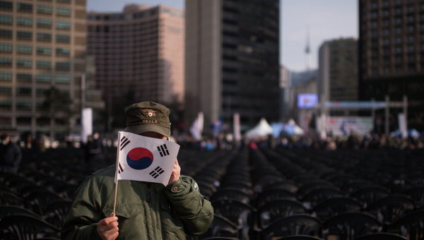 Активист против Северной Кореи держит флаг Южной Кореи во время демонстрации в Сеуле
