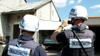 Представители ОБСЕ осматривают повреждения, нанесенные жилому дому в результате обстрела поселка Крутая балка