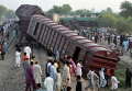 Местные жители собираются на месте, где столкнулись два поезда, Пакистан