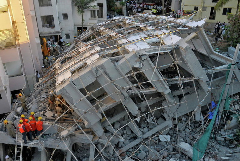 Работники полиции и спасатели ищут выживших под обломками на месте рухнувшего здания в Бангалоре, Индия