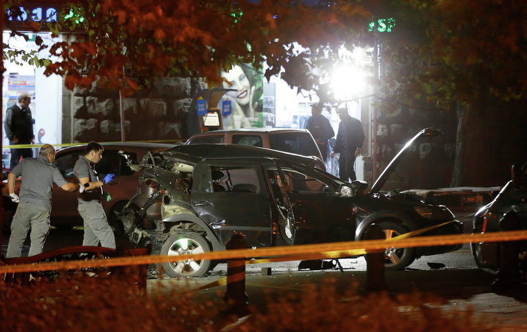 Офицеры осматривают взорванную машину оппозиционного депутата Гиви Таргамадзе в Тбилиси, Грузия