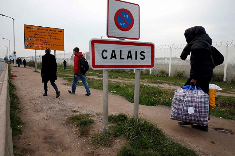 Мигранты покидают лагерь для беженцев во французском Кале