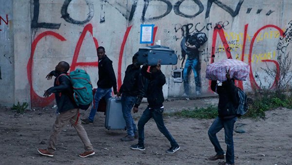 Мигранты в центре для беженцев в Кале