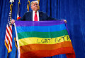 Кандидат в президенты США от республиканцев Дональд Трамп держит радужный флаг, на котором написано ЛГБТ за Трампа в ходе предвыборного митинга в городе Грили, штат Колорадо