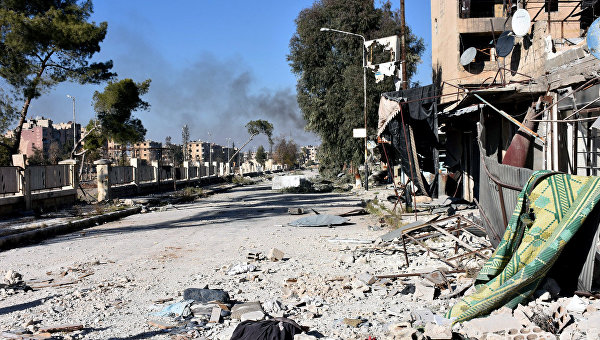 Дым на одной из улиц после того, ка правительственные силы взяли под контроль район в сирийском Алеппо