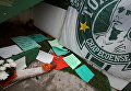 Цветы перед флагом бразильской футбольной команды Chapecoense, игроки которой погибли при крушении самолета