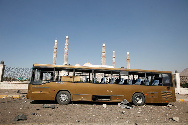 Поврежденный военный автобус на месте авиаудара вблизи мечети Аль-Салеха в Сане, Йемен