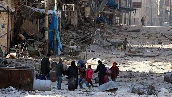 Сирийцы идут между обломками разрушенных зданий
