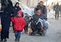 Люди с вещами готовятся к эвакуации из Алеппо