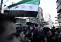 Сирийские мужчины в удерживаемом повстанцами городе Сакба, на восточной окраине столицы Дамаска, во время демонстрации против сирийского режима