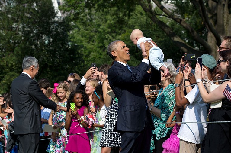 Барак Обама держит на руках ребенка
