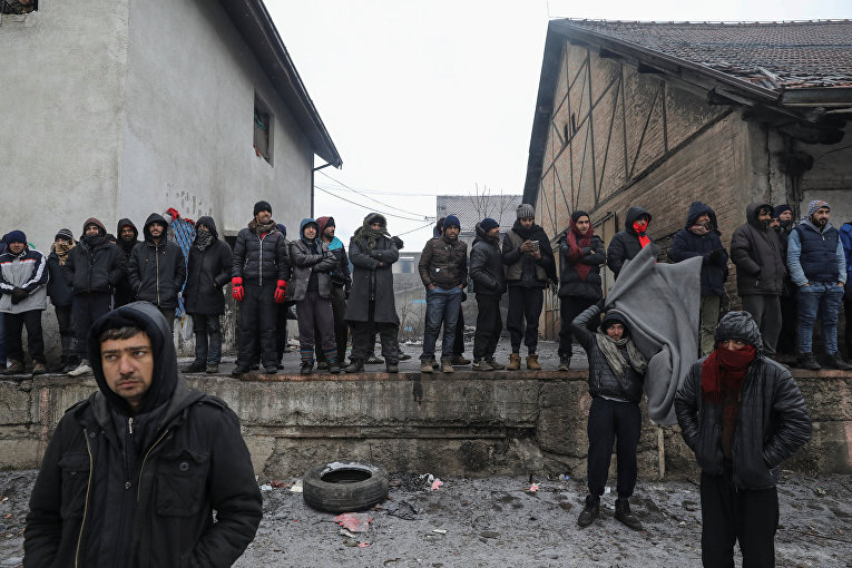 Мигранты участвуют в акции протеста за пределами заброшенного склада в Белграде