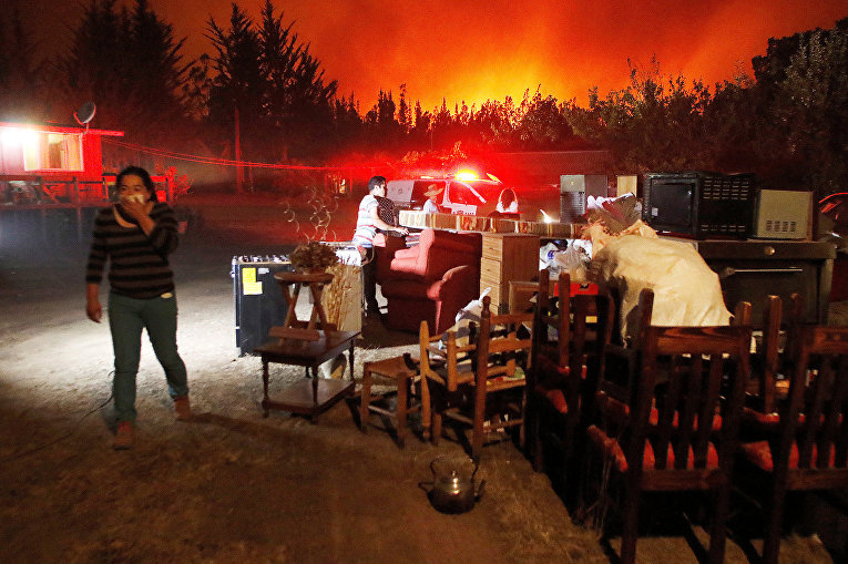 Чилийцы с вещами во время эвакуации в коммуне Вичукен в районе Мауле в результате лесных пожаров