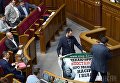 Народные депутаты снимают плакат с трибуны парламента во время заседания Верховной Рады Украины