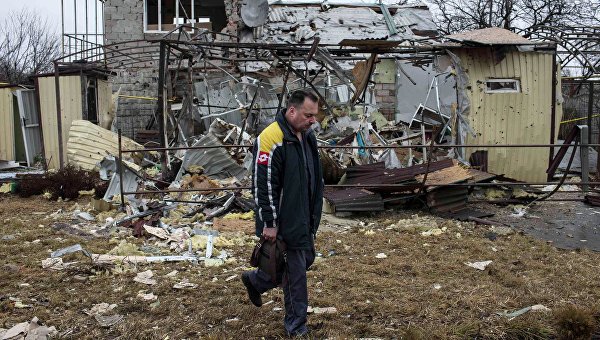 Мужчина проходит мимо разрушенного в результате обстрела дома в жилом районе Донецка (5 марта 2015 года)