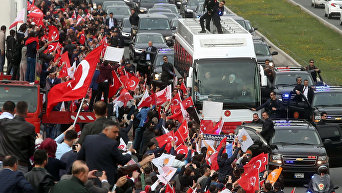 Президент Турции Реджеп Тайип Эрдоган и его супруга Эмине Эрдоган из автобуса приветствуют сторонников конституционного референдума.