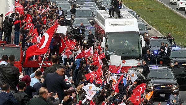 Президент Турции Реджеп Тайип Эрдоган и его супруга Эмине Эрдоган из автобуса приветствуют сторонников конституционного референдума.