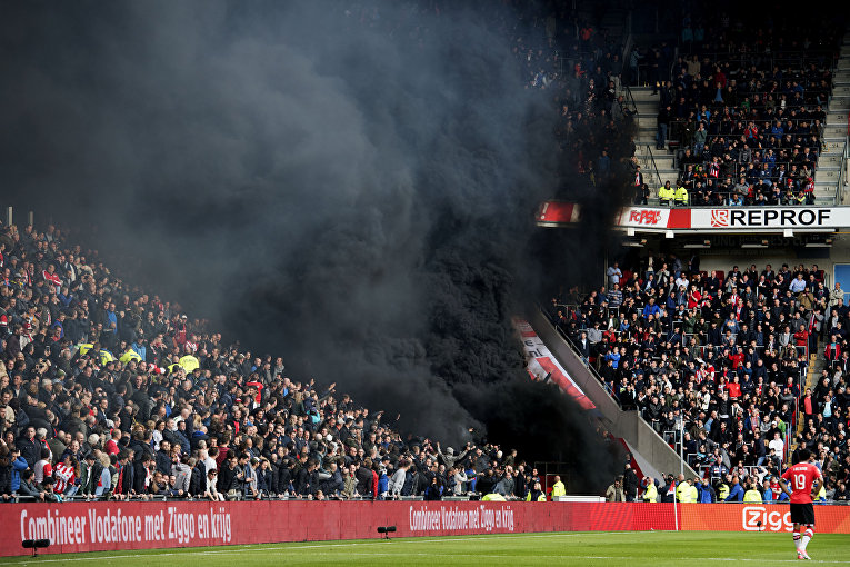 В Амстердаме на футбольном матче ПСВ Эйндховен – Аякс фанатские трибуны окутало черным облаком после того, как болельщики Эйндховена использовали дымовые шашки.