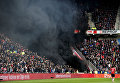 В Амстердаме на футбольном матче ПСВ Эйндховен – Аякс фанатские трибуны окутало черным облаком после того, как болельщики Эйндховена использовали дымовые шашки.