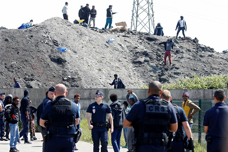 Французская полиция и мигранты в точке распространения продовольствия в Кале
