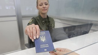 Сотрудник пограничной службы проводит паспортный контроль в аэропорту Киев