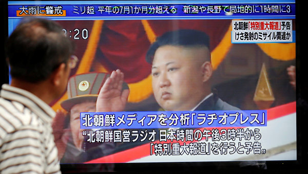 Мужчина в Токио (Япония) смотрит на уличный монитор, показывающий новости о Северной Корее, которая провела испытания баллистической ракеты