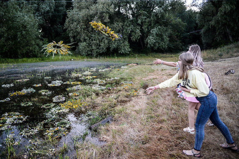 Девушки по традиции бросают венки из цветов в воду