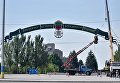 Работники коммунальной службы устанавливают арку с гербом города и вывеской Запоріжжя - колиска державності України, на площади Фестивальной, в Запорожье