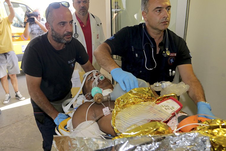 Медики переносят человека, пострадавшего во время землетрясения на Крите