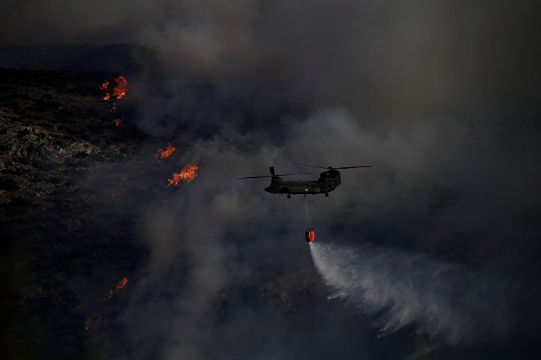 Вертолет Chinook тушит масштабный лесной пожар недалеко от Афин.