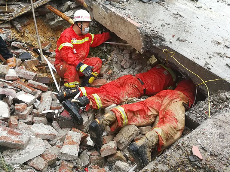 Китайские спасатели пытаются найти выживших после оползня, вызванного наводнениями.
