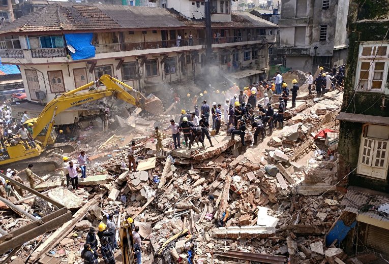 Пожарные и спасатели ищут выживших на месте рухнувшего здания в Мумбаи