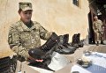 Военнослужащий проверяет обувь, которую отправят в воинские части, в зону АТО, на одном из военных складов в Харькове