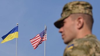 Украинский военный на фоне флагов США и Украины