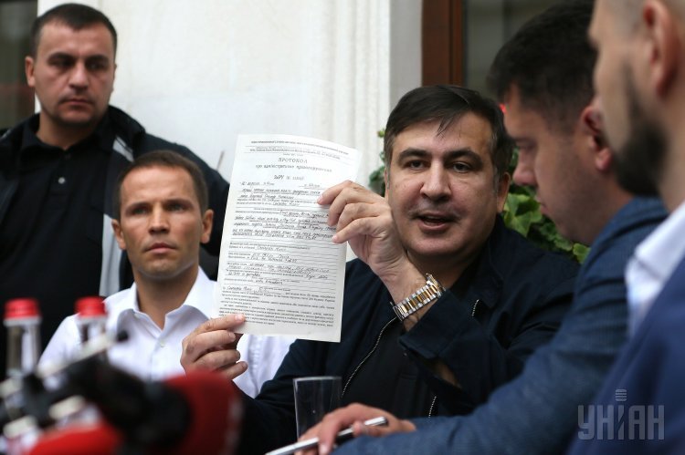 Экс-председатель Одесской ОГА Михеил Саакашвили держит протокол об административном правонарушении, на улице перед входом в гостиницу Леополис, во Львове, 12 сентября 2017 г.