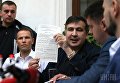 Экс-председатель Одесской ОГА Михеил Саакашвили держит протокол об административном правонарушении, на улице перед входом в гостиницу Леополис, во Львове, 12 сентября 2017 г.