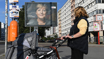 Плакат с изображением канцлера Германии, лидера Христианско-демократического союза Ангелы Меркель на одной из улиц Берлина накануне парламентских выборов в Германии