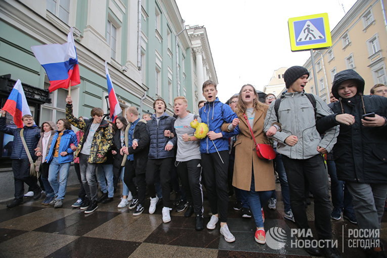 Участники несанкционированной акции протеста идут по улице Малая Дмитровка в Москве, 7 октября 2017