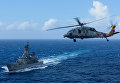 Морской ястреб ВВС США MH-60S летит над японским кораблем морской силы самообороны JS Shimakaze на юго-запад от Корейского полуострова.