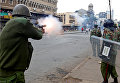 Омоновцы разжигают слезоточивый газ, разгоняя сторонников коалиции Национального суперсоюза Кении (НАСА) во время протеста на улице в Найроби.