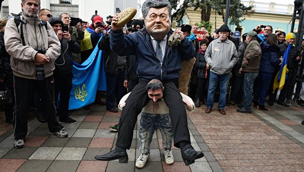 Ряженый в костюме президента Украины Петра Порошенко, который сидит на плечах у украинского казака, во время вече у здания Верховной Рады в Киеве
