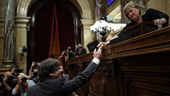 Глава Каталонии Карлес Пучдемон вручает свой бюллетень во время голосования по вопросу о независимости от Испании в региональном парламенте Каталонии в Барселоне